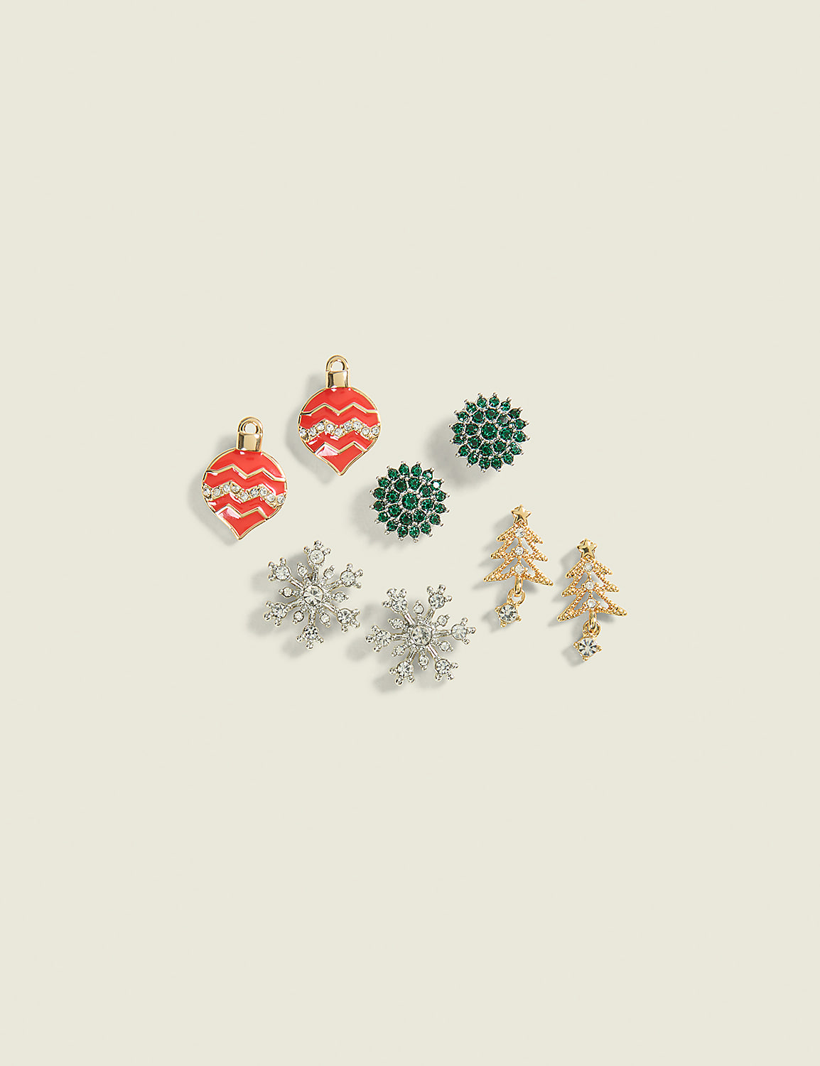 A collection of festive Christmas-themed earrings, including ornaments, snowflakes, and trees, are arranged on a pale cream background. Product Image 1