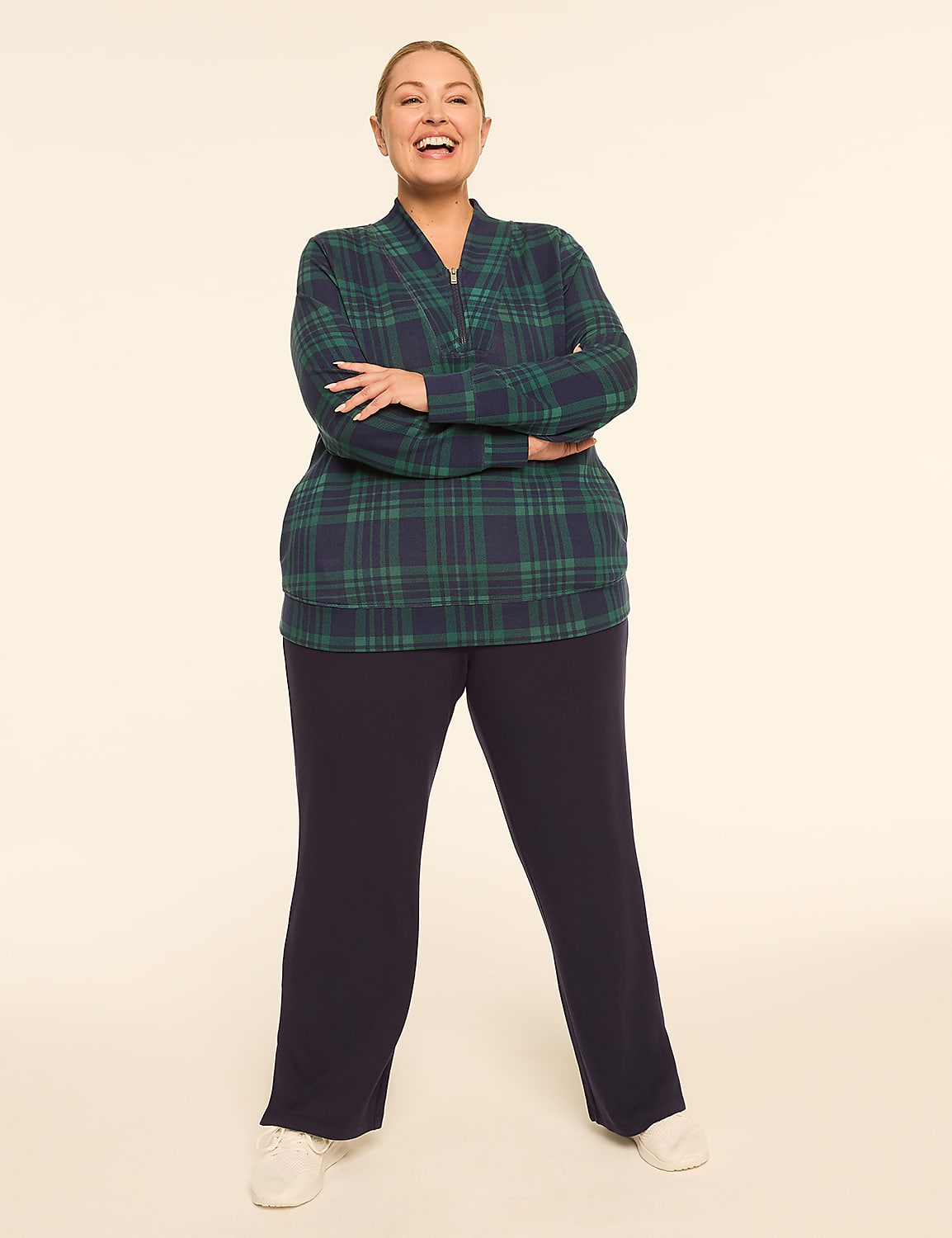 A smiling woman in a green and blue plaid shirt and navy pants stands with her arms crossed against a plain, light-colored background. Product Image 3