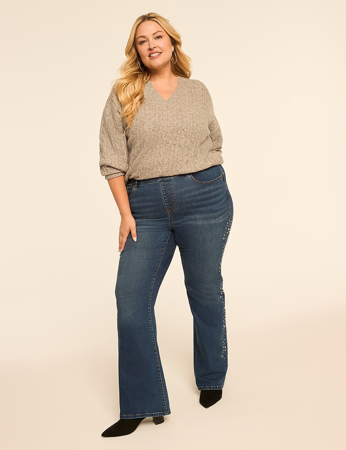 A blonde woman in a grey sweater and embellished jeans stands against a plain, light-colored background. Product Image 3