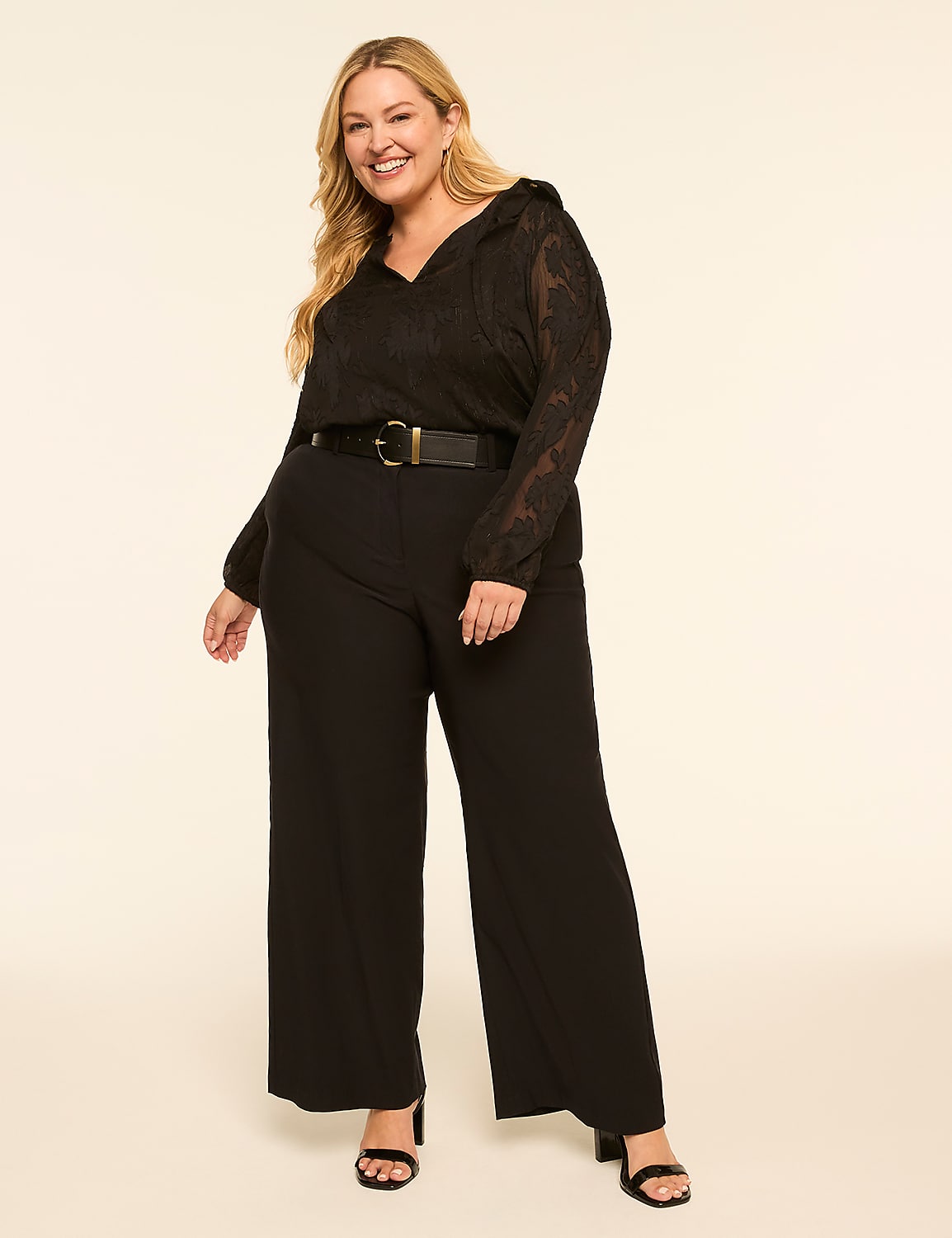 A smiling woman in a black lace-sleeved top and wide-leg pants stands against a plain, light-colored background. Product Image 3