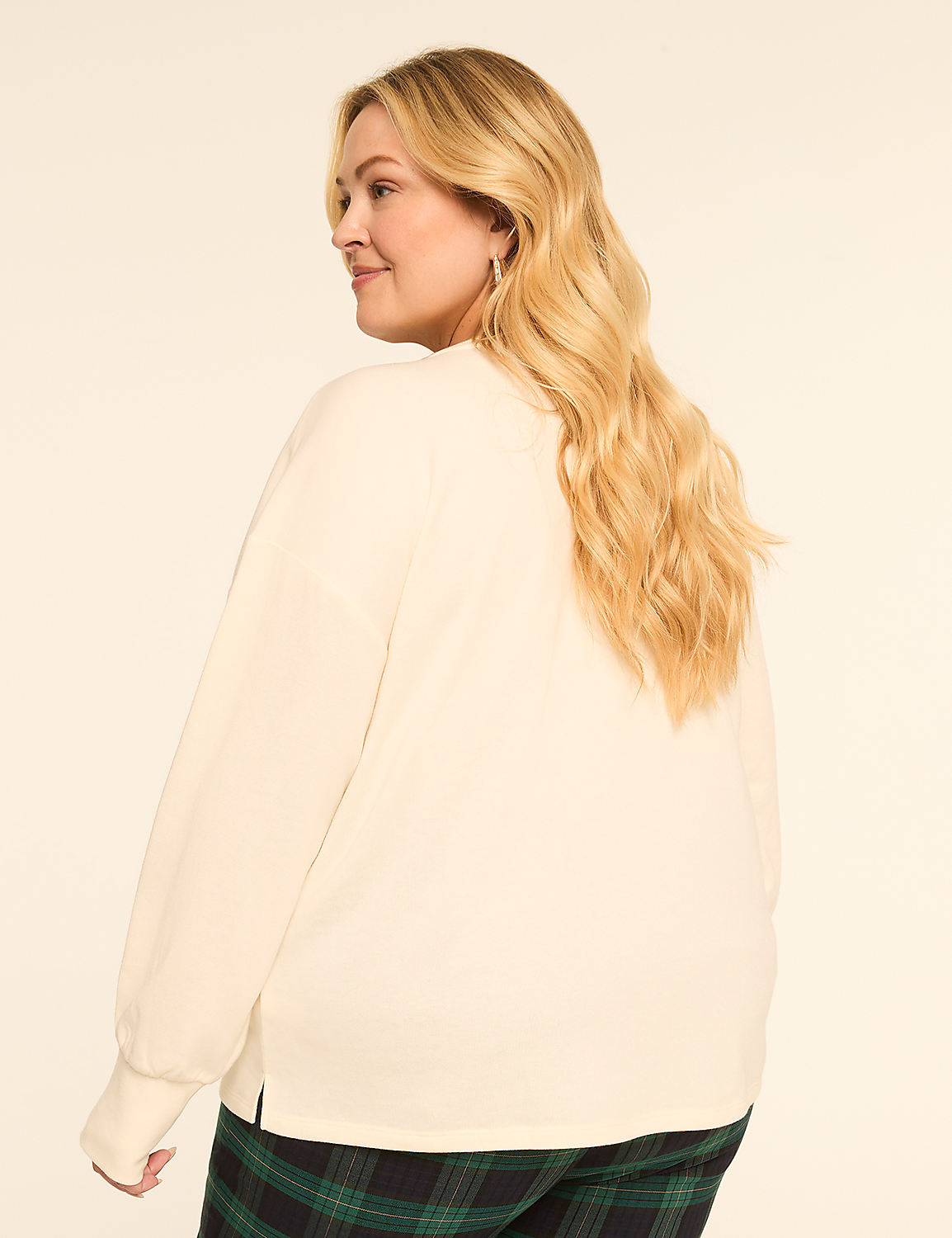 A blonde woman in a cream-colored sweatshirt and plaid pants stands against a plain, light-colored background. Product Image 2