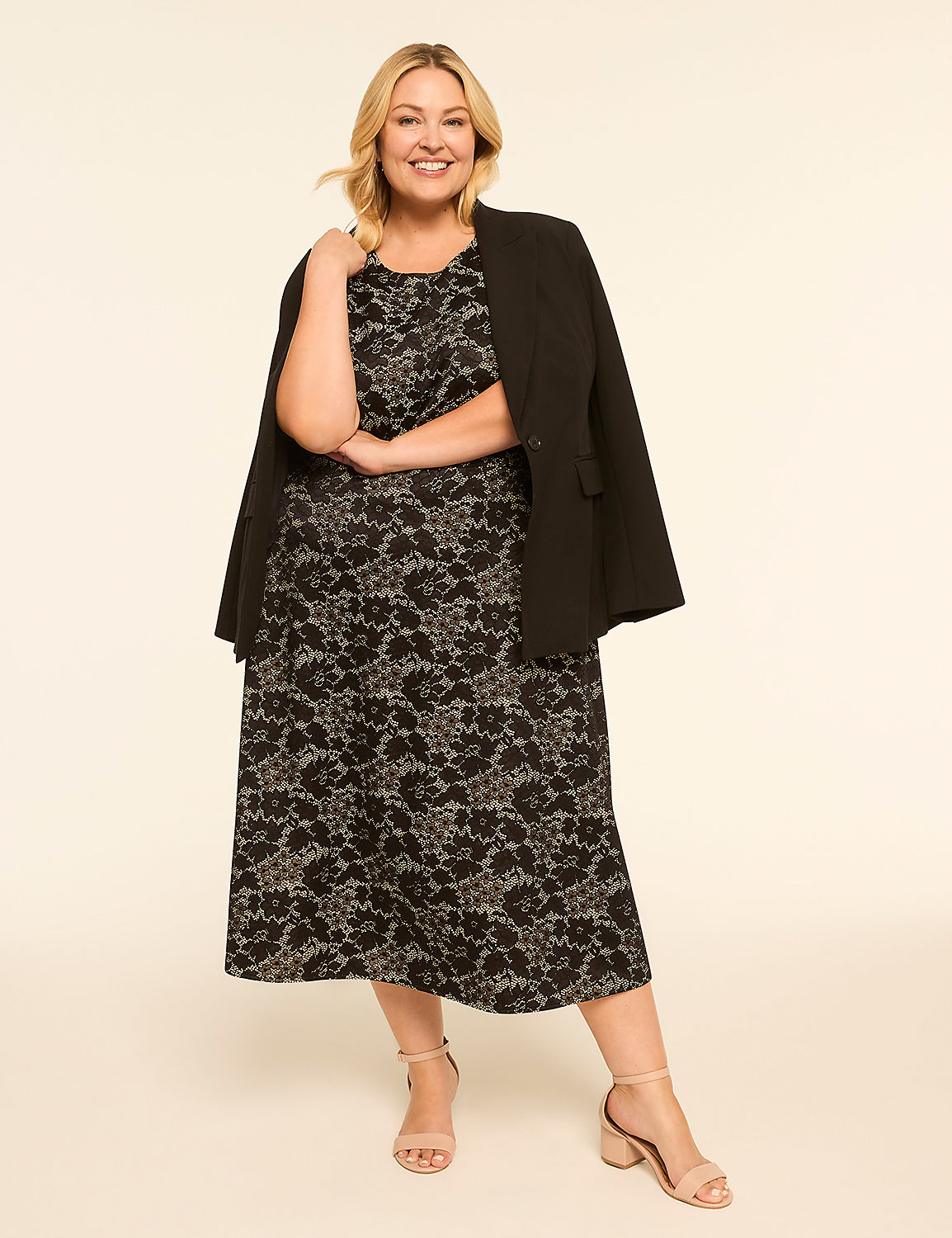 A smiling woman in a black lace dress and blazer stands against a plain, light-colored background. Product Image 4