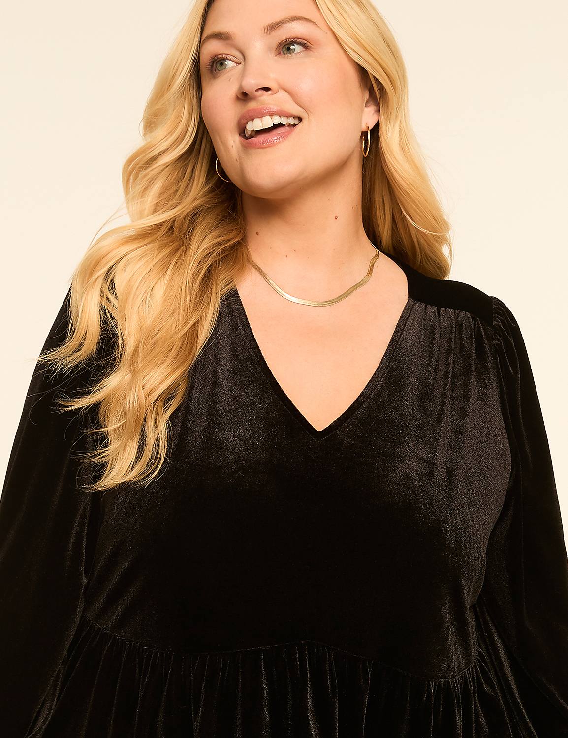 A smiling blonde woman in a black velvet dress stands against a plain cream background. Product Image 3