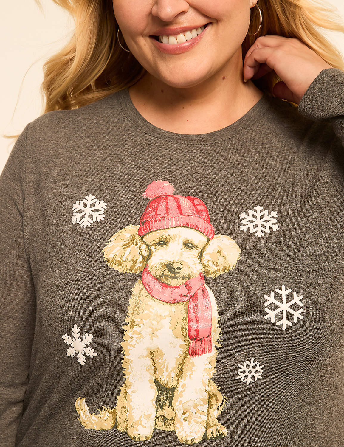 A woman smiles as a fluffy dog wearing a pink hat and scarf is printed on her gray shirt, surrounded by snowflakes. Product Image 4