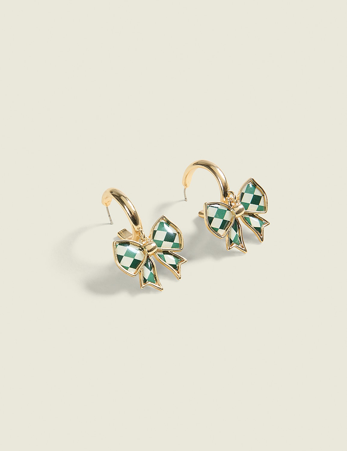 A pair of gold hoop earrings with green checkered bow charms hang against a plain, light-colored background. Product Image 1