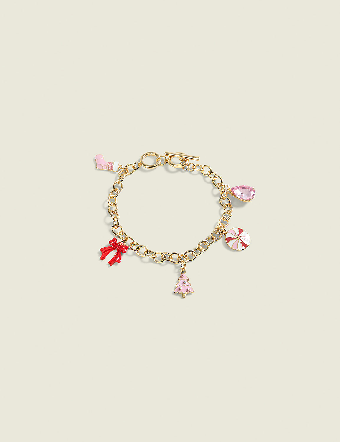 A gold charm bracelet with festive holiday-themed charms like a candy cane, Christmas tree, and bow hangs against a plain, light-colored background. Product Image 1