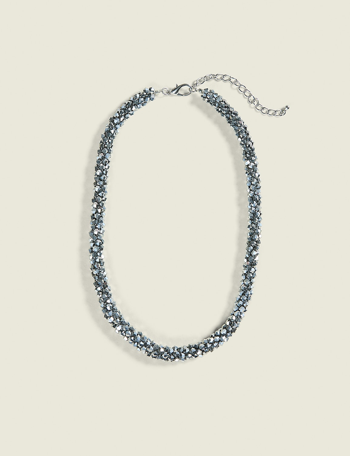A sparkly, silver beaded necklace with a delicate chain rests on a plain, light beige background. Product Image 1