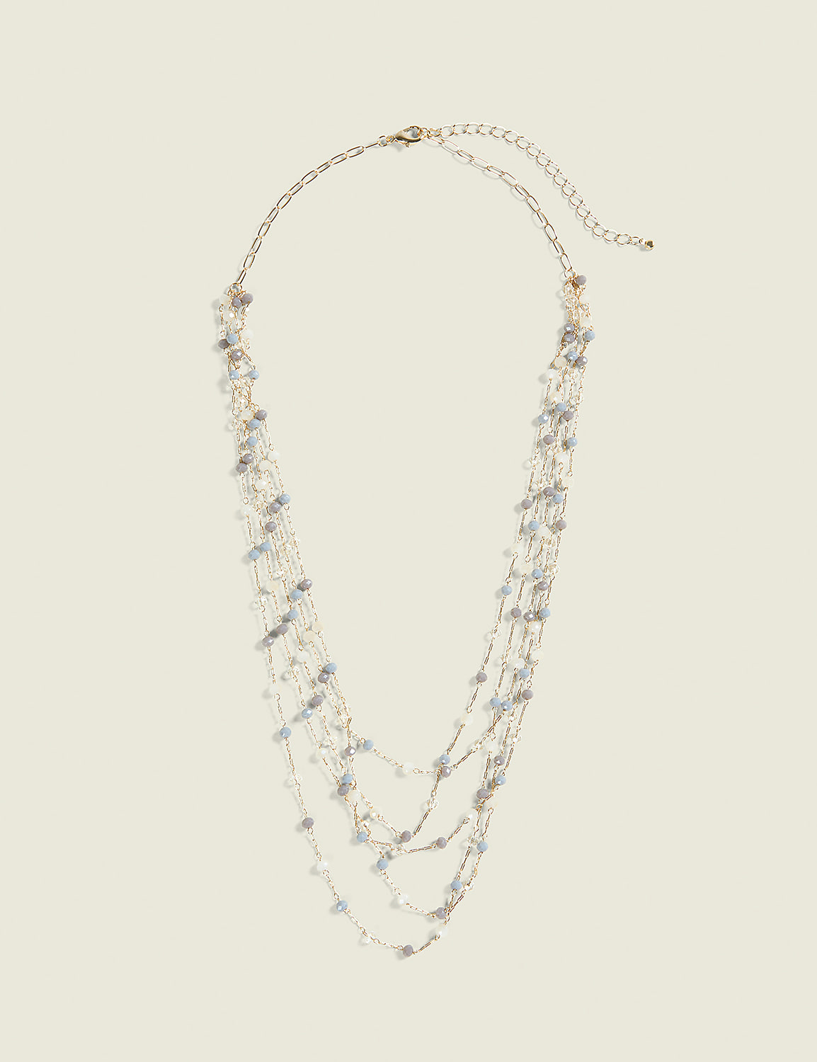 A delicate, multi-strand necklace with small, light-colored beads hangs against a plain, light beige background. Product Image 1