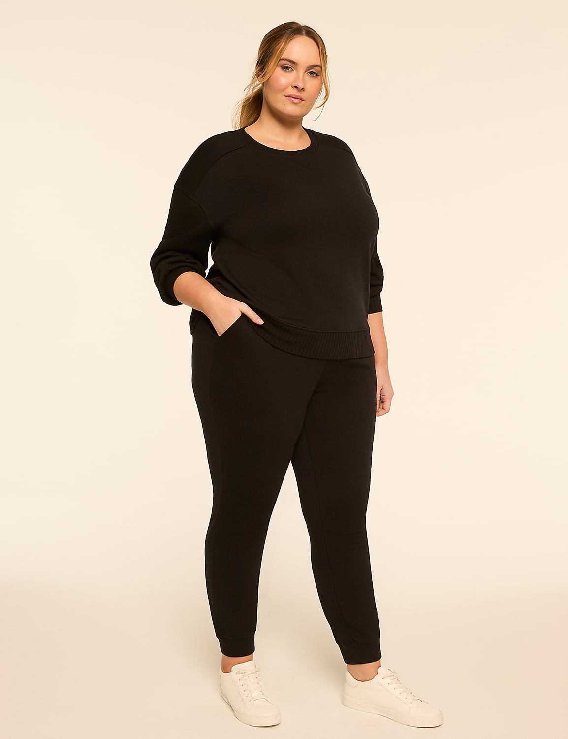 A woman in a black loungewear set stands with her hand in her pocket against a plain, light-colored background. Product Image 3