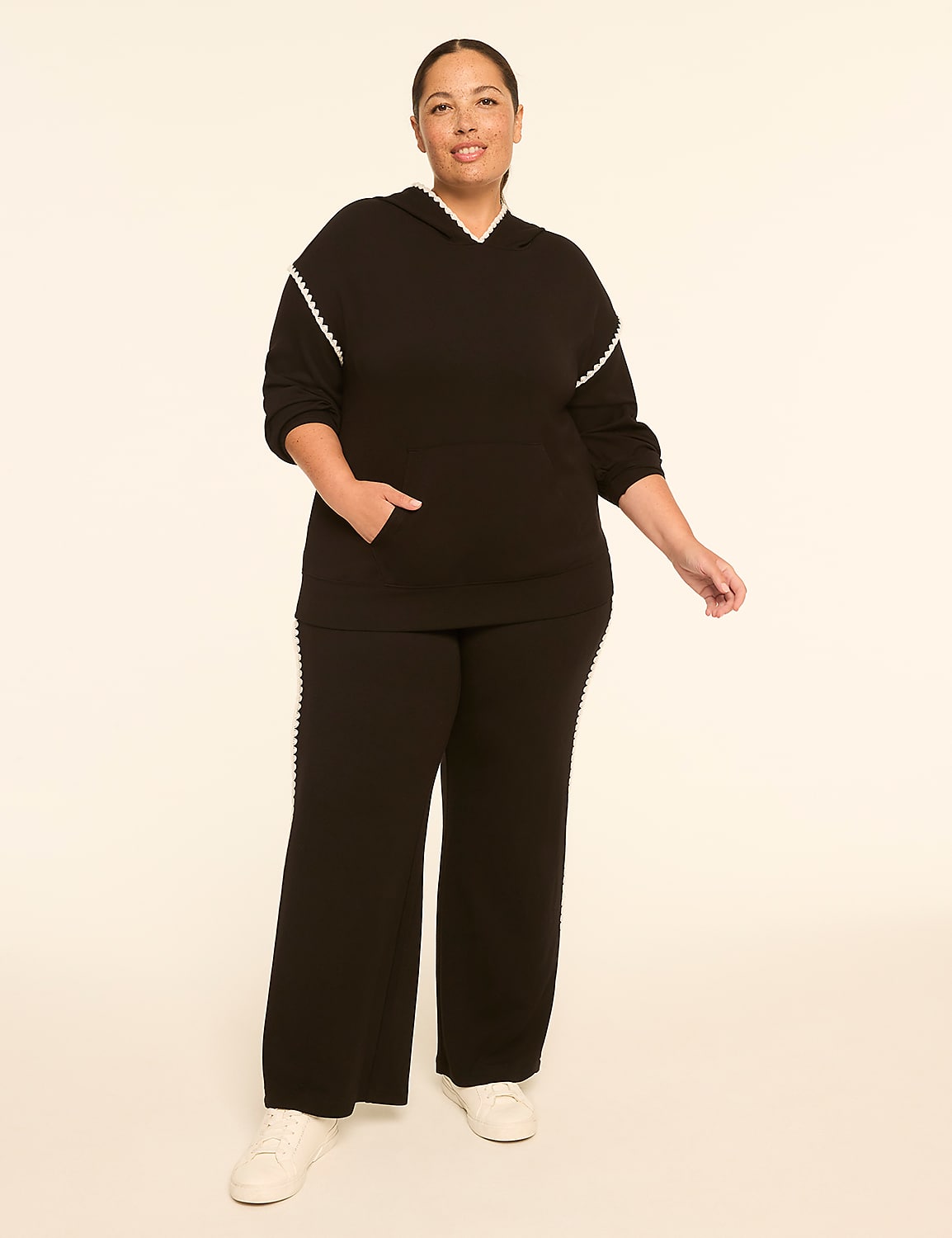 A woman in a black loungewear set with pearl trim stands against a plain, light-colored background. Product Image 3