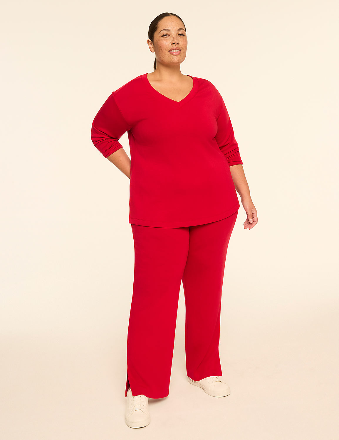 A woman in a red v-neck top and matching pants stands against a plain, light-colored background. Product Image 3