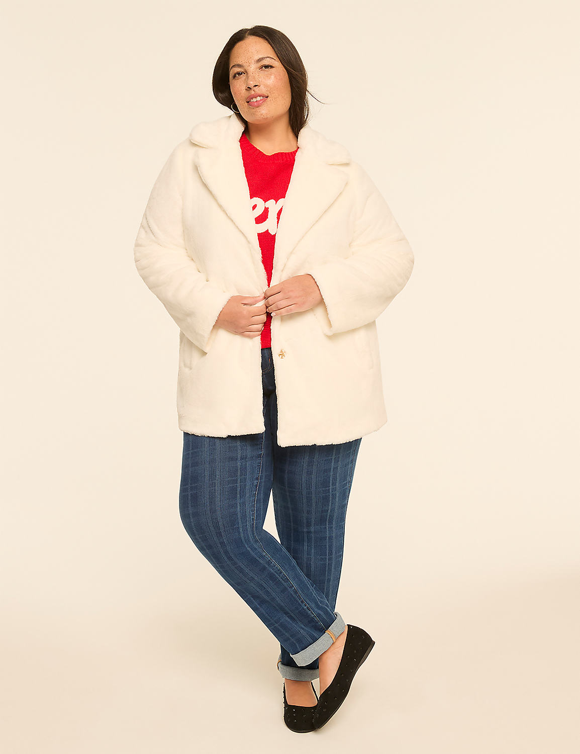 A woman in a white coat, red sweater, and blue jeans stands against a plain, light-colored background. Product Image 3