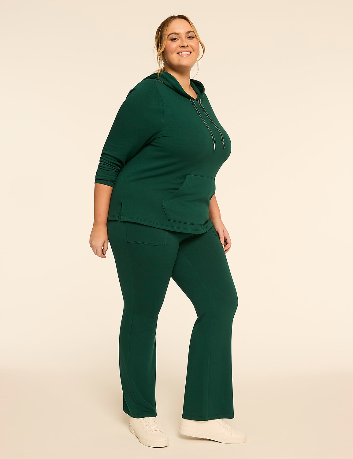 A woman in a green hooded sweatshirt and matching pants stands against a plain, light-colored background. Product Image 3