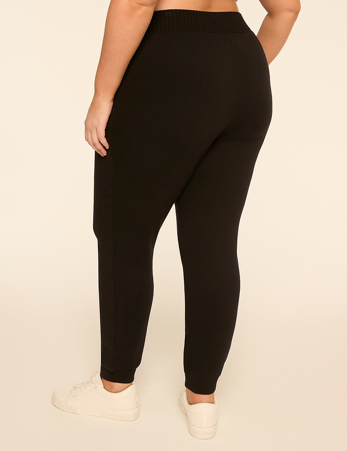 A person wearing black joggers and white sneakers stands against a plain, light-colored background. Product Image 2