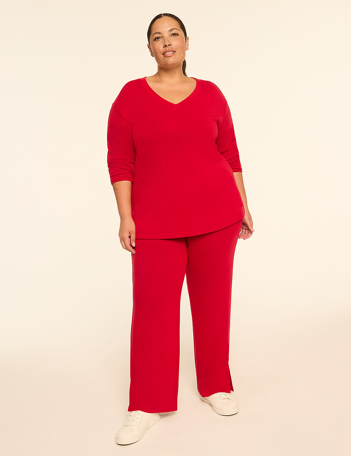 A woman in a red v-neck top and matching pants stands against a plain, light-colored background. Product Image 3