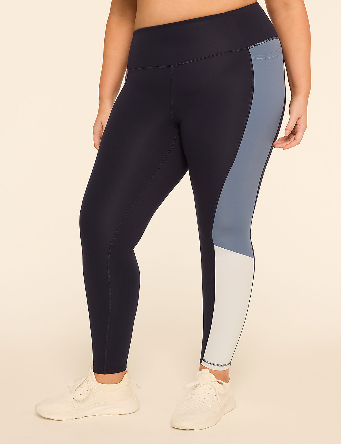A person wearing navy blue leggings with light blue and white color blocking stands against a plain, light-colored background. Product Image 1