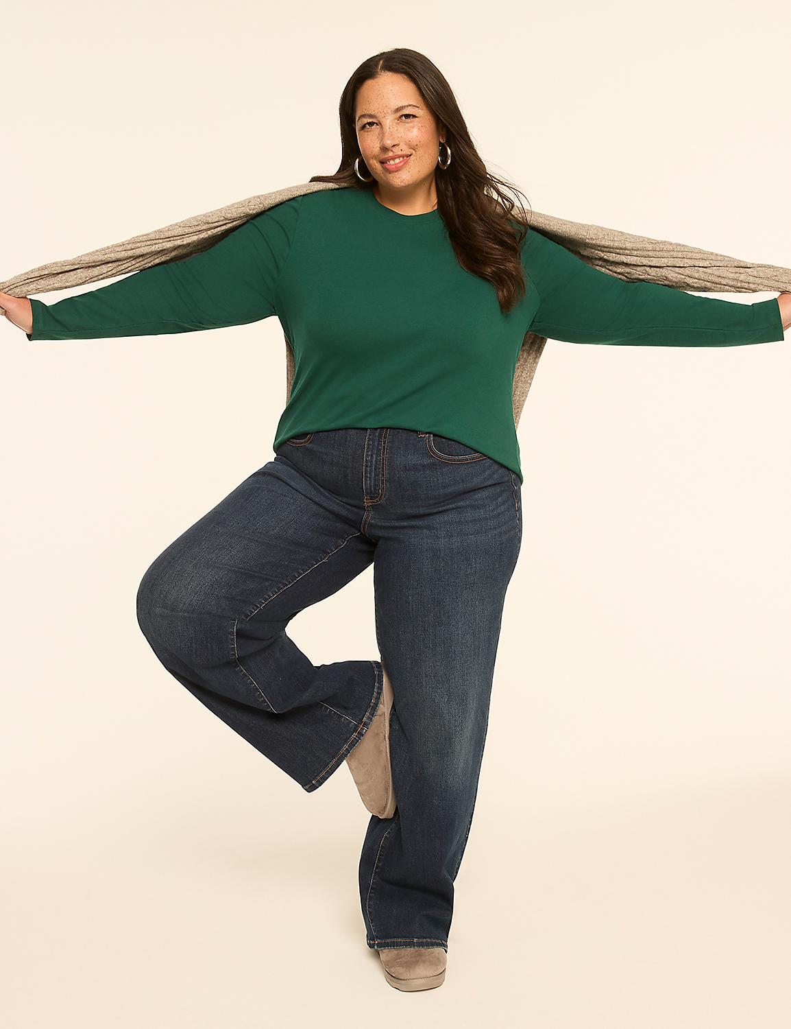 A woman in a green top and blue jeans stands on one leg with a scarf draped over her shoulders against a plain, light-colored background. Product Image 3