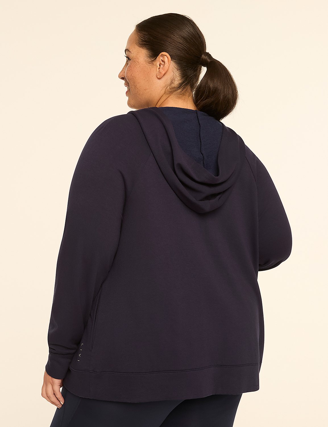A woman in a navy hoodie stands against a plain, light-colored background. Product Image 2