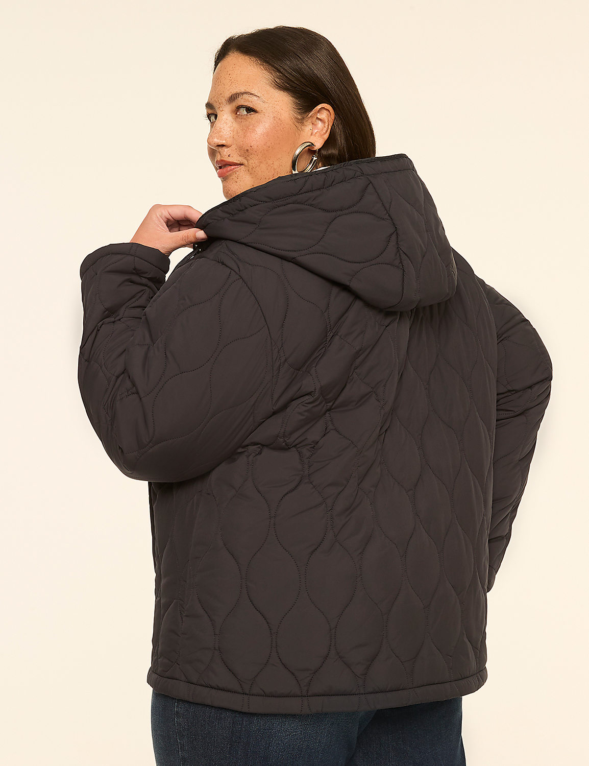 A woman in a quilted black jacket stands against a plain, light-colored background. Product Image 2