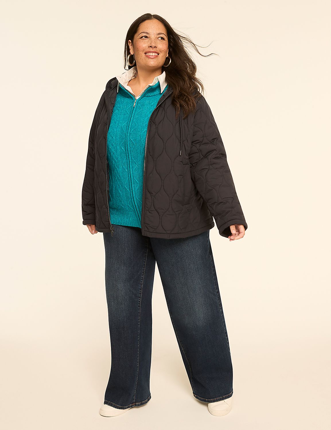 A woman in a quilted jacket, teal sweater, and dark jeans stands against a plain, light-colored background. Product Image 3