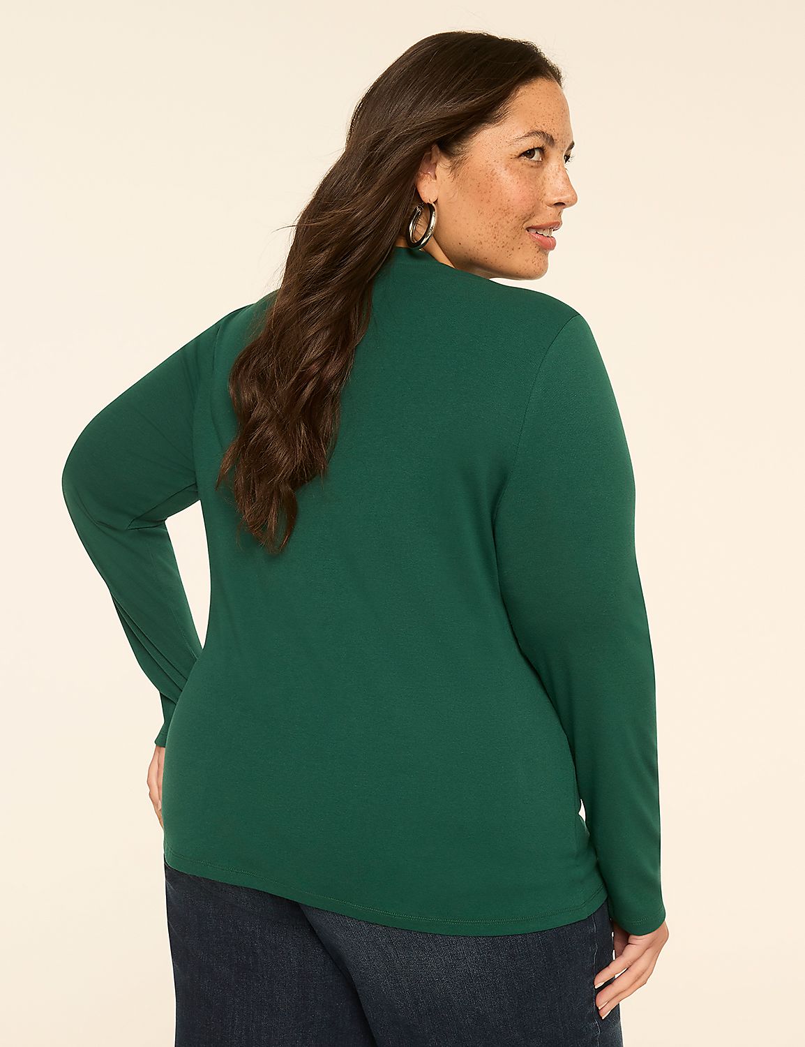 A woman in a green turtleneck and jeans stands against a plain, light-colored background. Product Image 2