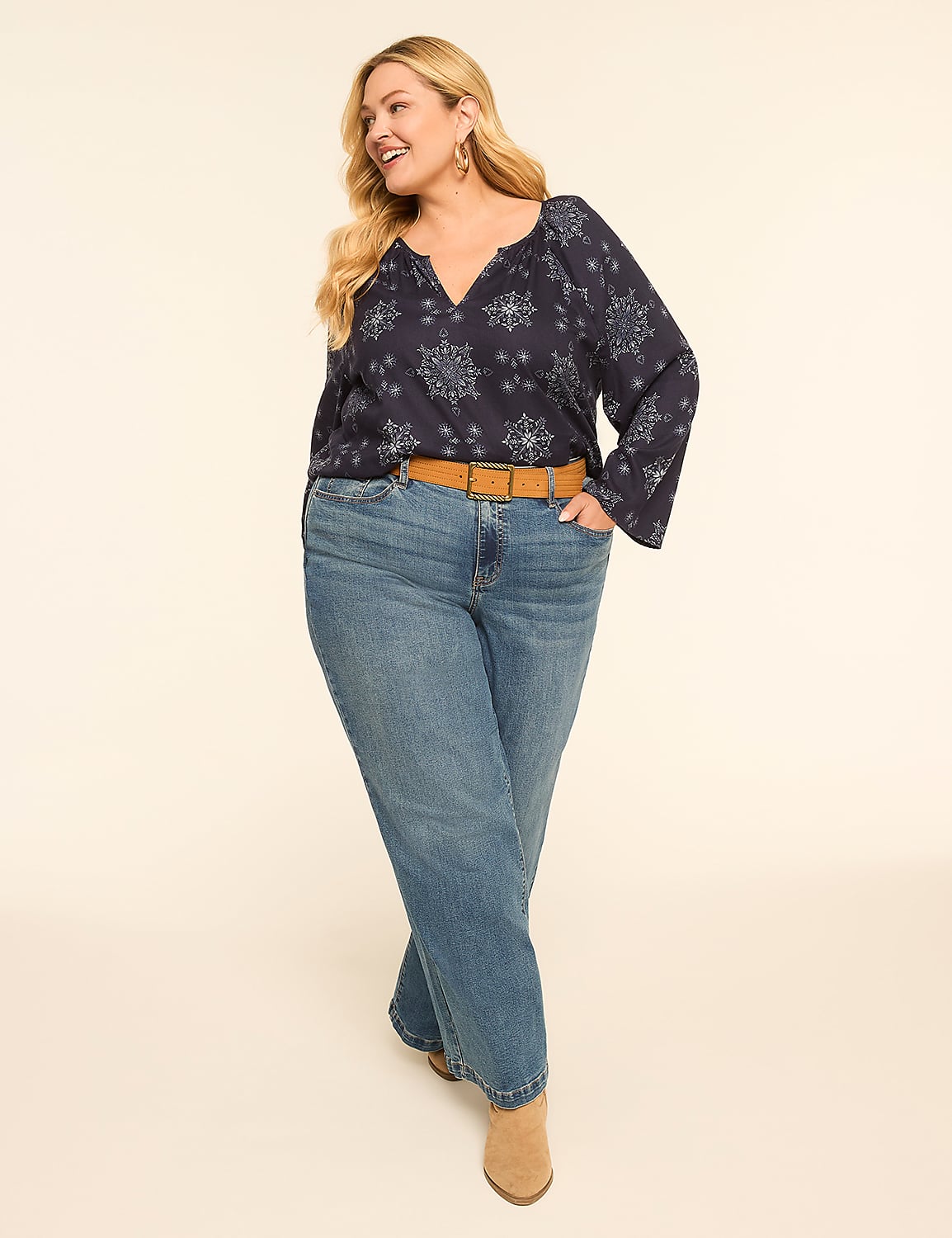 A woman in a patterned navy blouse and blue jeans stands against a plain, light-colored background. Product Image 3