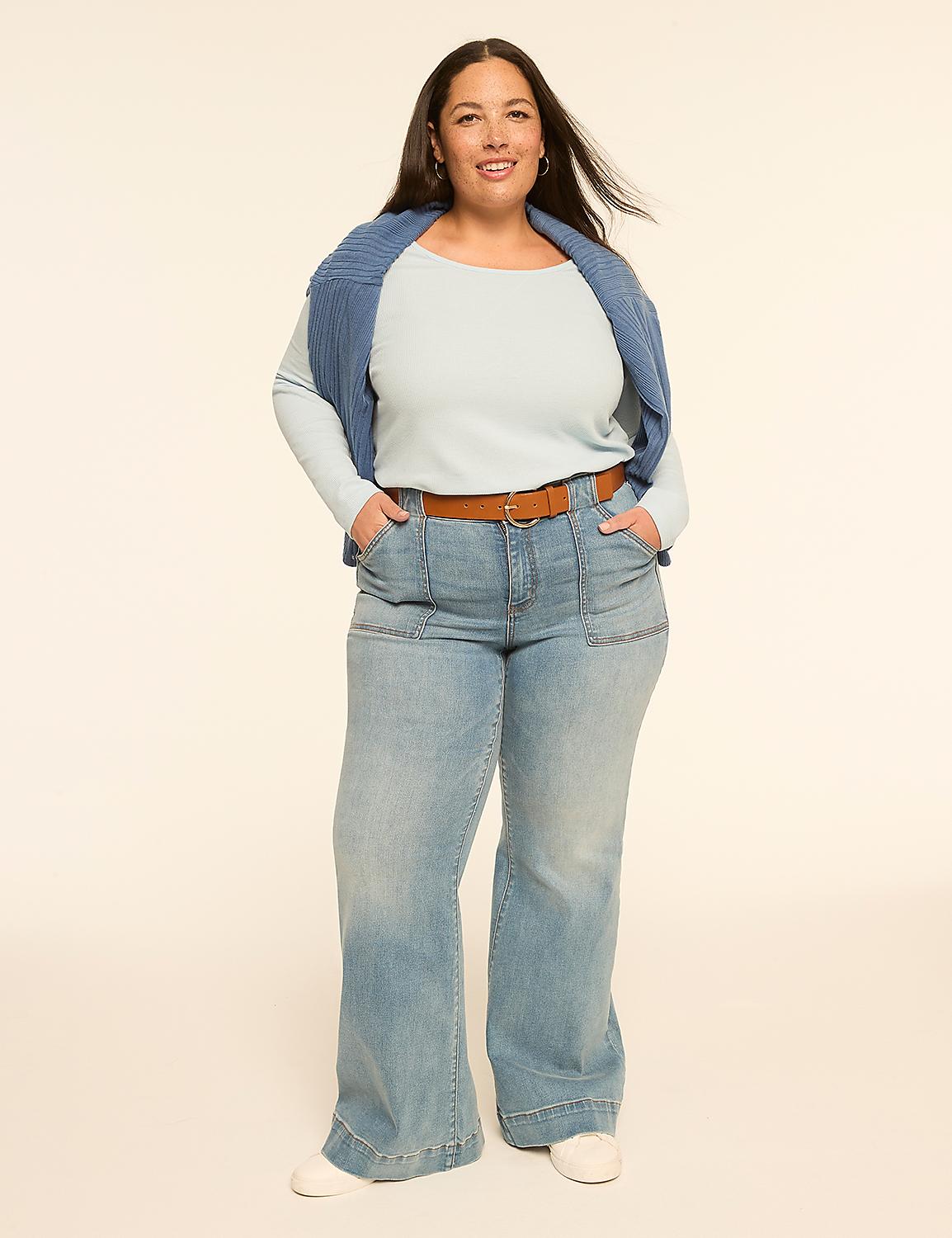 A woman in a light blue top, a blue sweater draped over her shoulders, and wide-leg jeans stands against a plain, light-colored background. Product Image 3