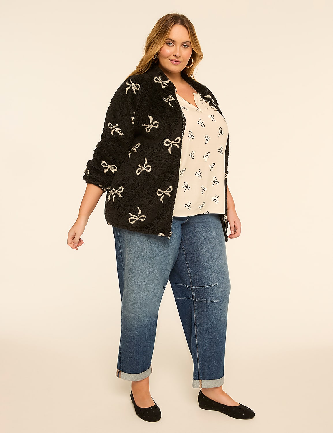 A woman in a black bow-print jacket and jeans stands against a plain, light-colored background. Product Image 3