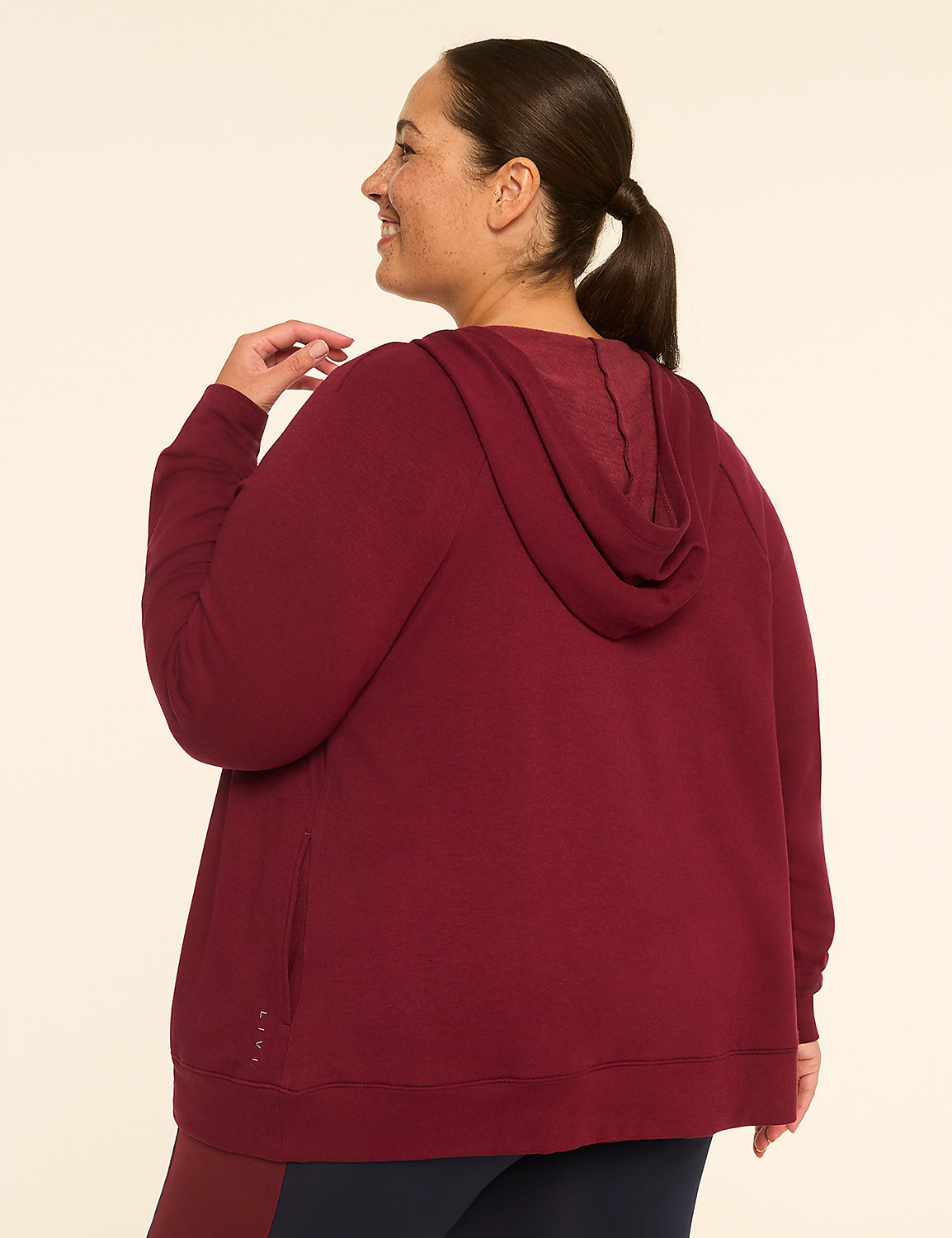 A woman in a maroon hoodie stands against a plain, light-colored background. Product Image 2