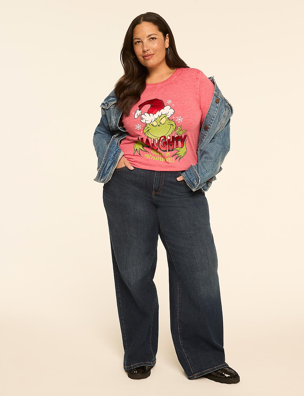 A woman in a pink Grinch t-shirt and denim jacket stands against a plain, light-colored background. Product Image 3