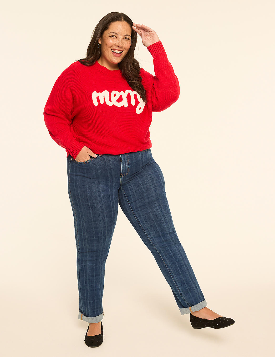 A smiling woman in a red "merry" sweater and striped jeans poses against a plain, light-colored background. Product Image 3