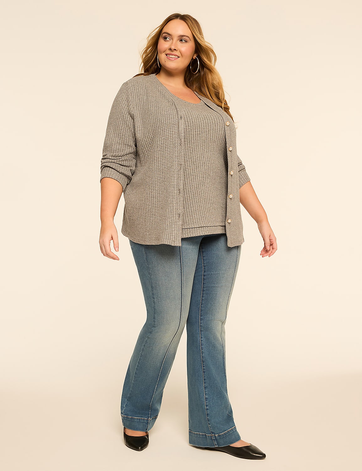 A woman in a gray cardigan and jeans stands against a plain, light-colored background. Product Image 3