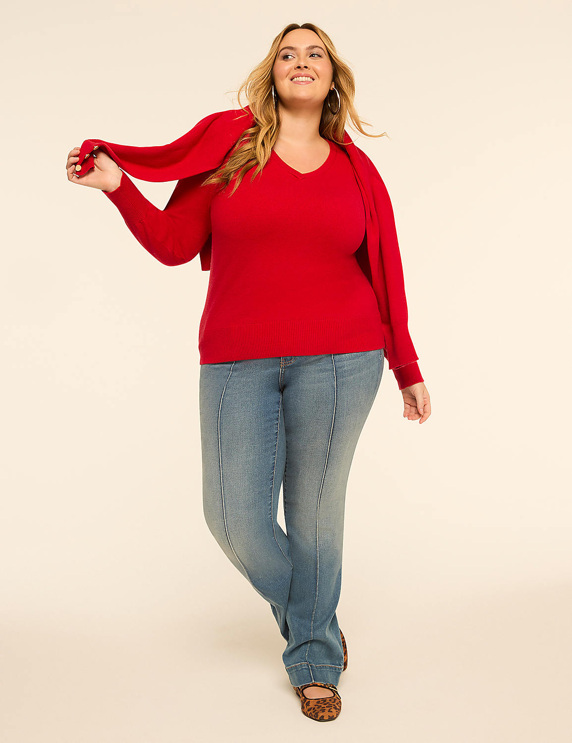 A smiling woman in a red sweater and jeans stands against a plain, light-colored background, holding a matching red scarf. Product Image 3