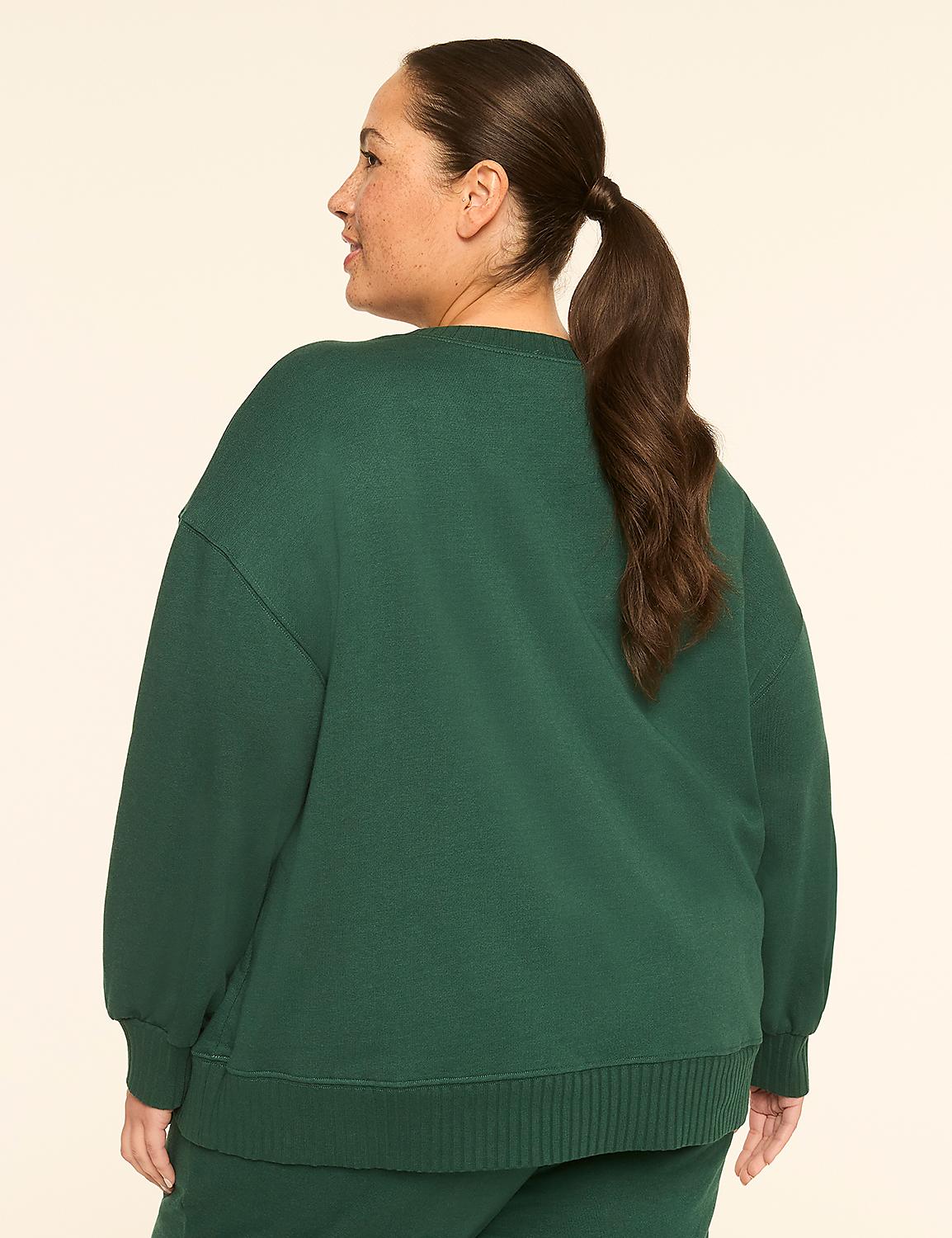 A woman in a green sweatshirt stands against a plain, light-colored background. Product Image 2