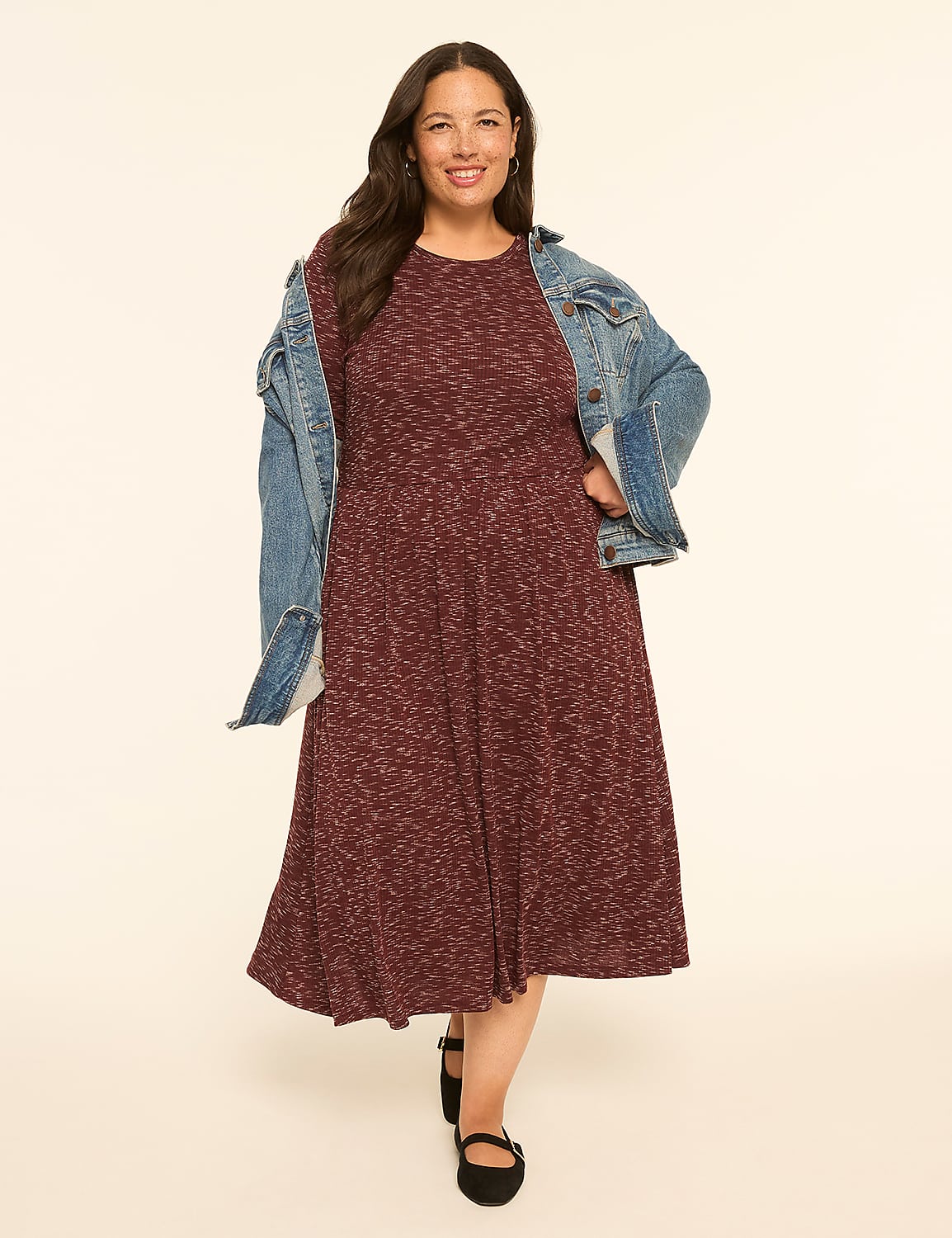 A smiling woman in a maroon dress and denim jacket stands against a plain, light-colored background. Product Image 4
