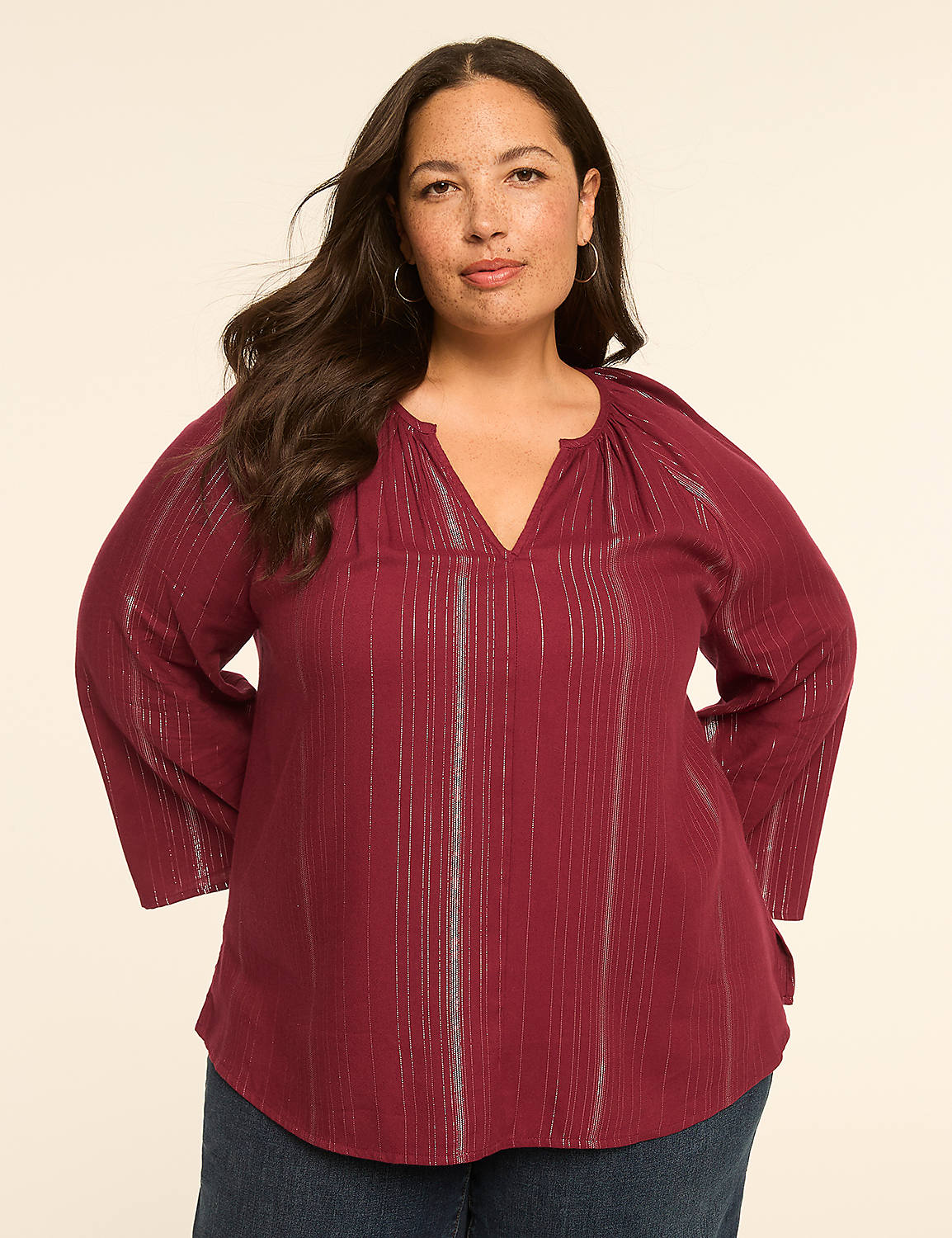 A woman in a burgundy striped top stands against a plain, light-colored background. Product Image 1