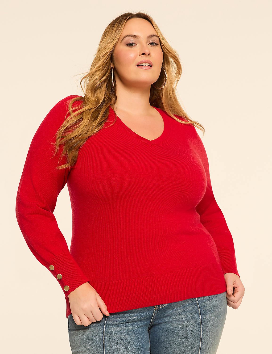 A woman in a red v-neck sweater and jeans stands against a plain, light-colored background. Product Image 1