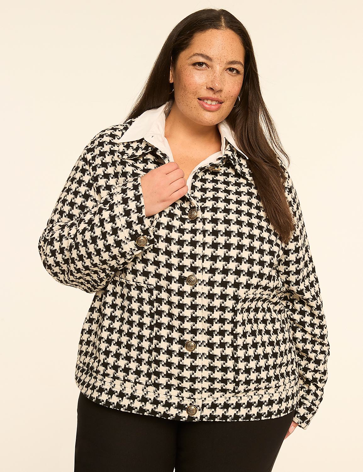 A woman in a houndstooth jacket stands against a plain, light-colored background. Product Image 1