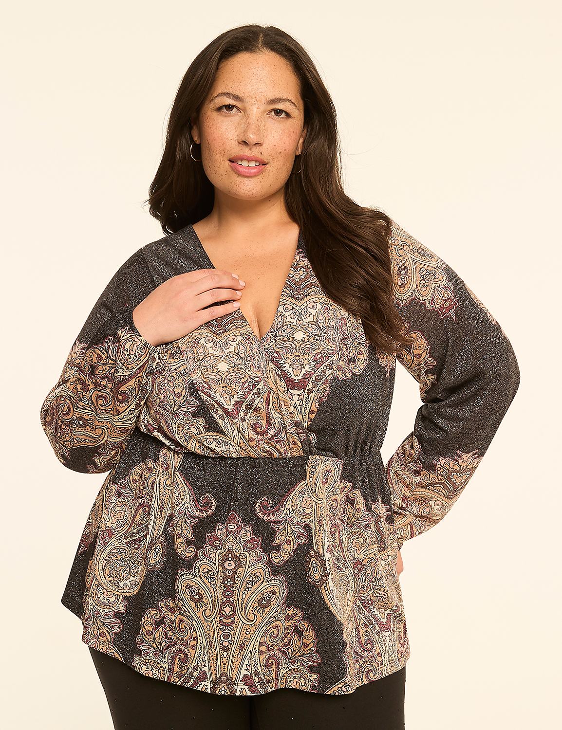 A woman in a patterned wrap top stands against a plain, light-colored background. Product Image 1