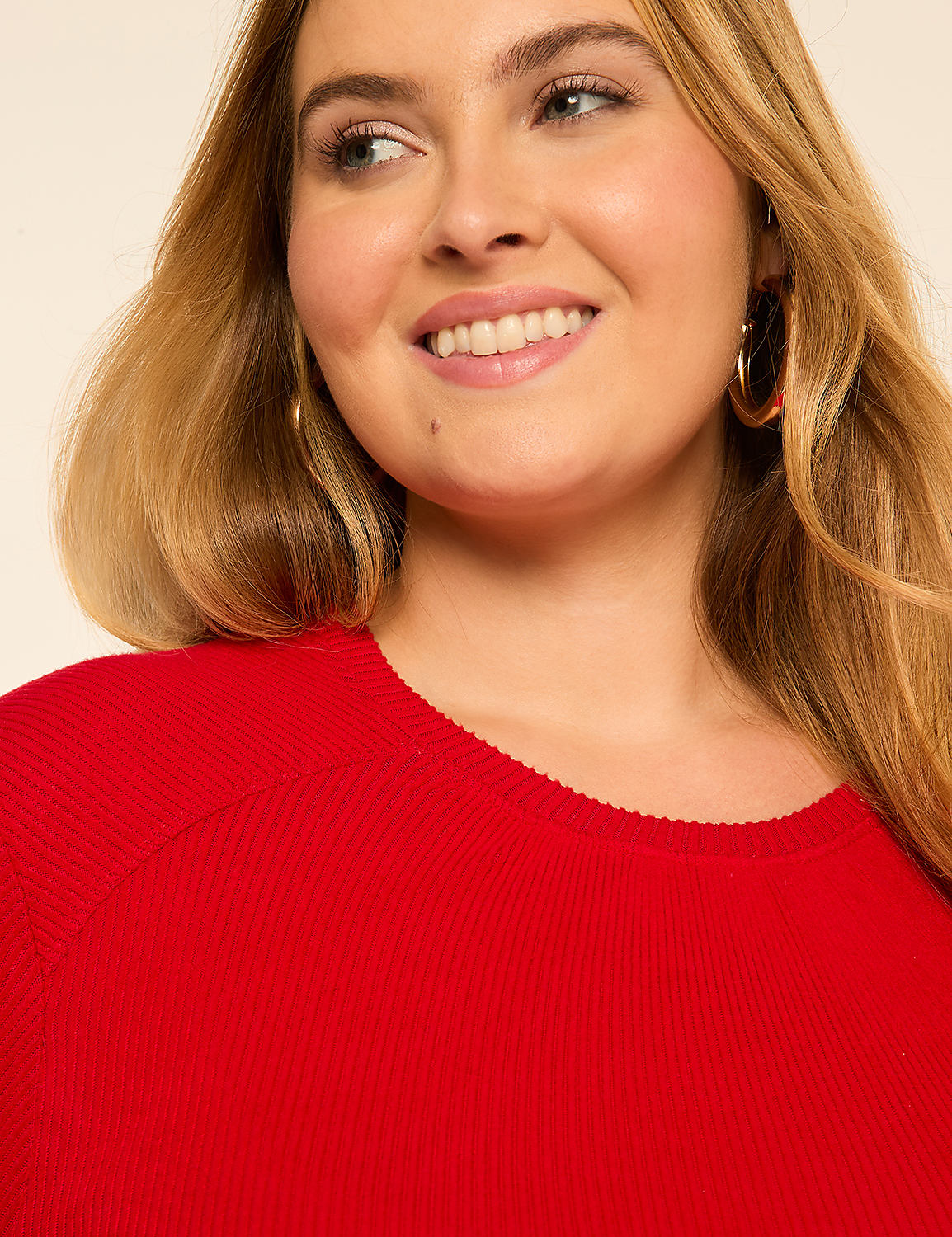 A smiling woman with blonde hair and hoop earrings wears a red ribbed top against a plain, light background. Product Image 4