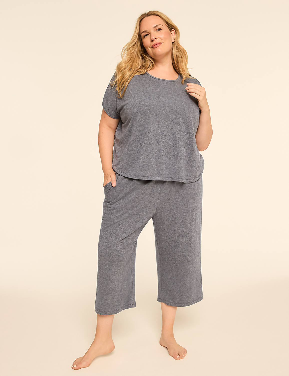 A woman in a grey pajama set stands with her hands in her pockets against a plain, light-colored background. Product Image 3