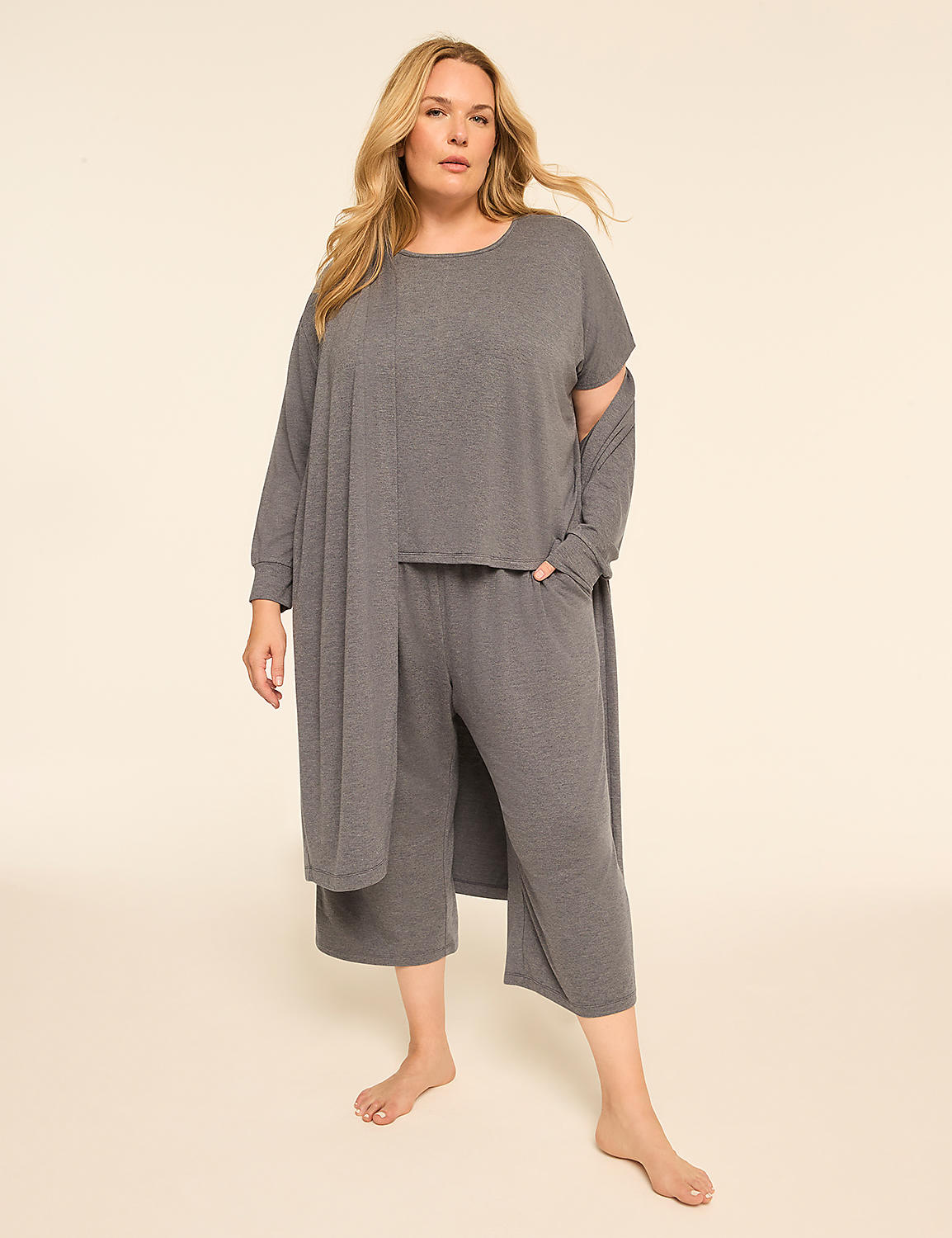 A woman in a grey loungewear set stands barefoot against a plain, light-colored background. Product Image 4
