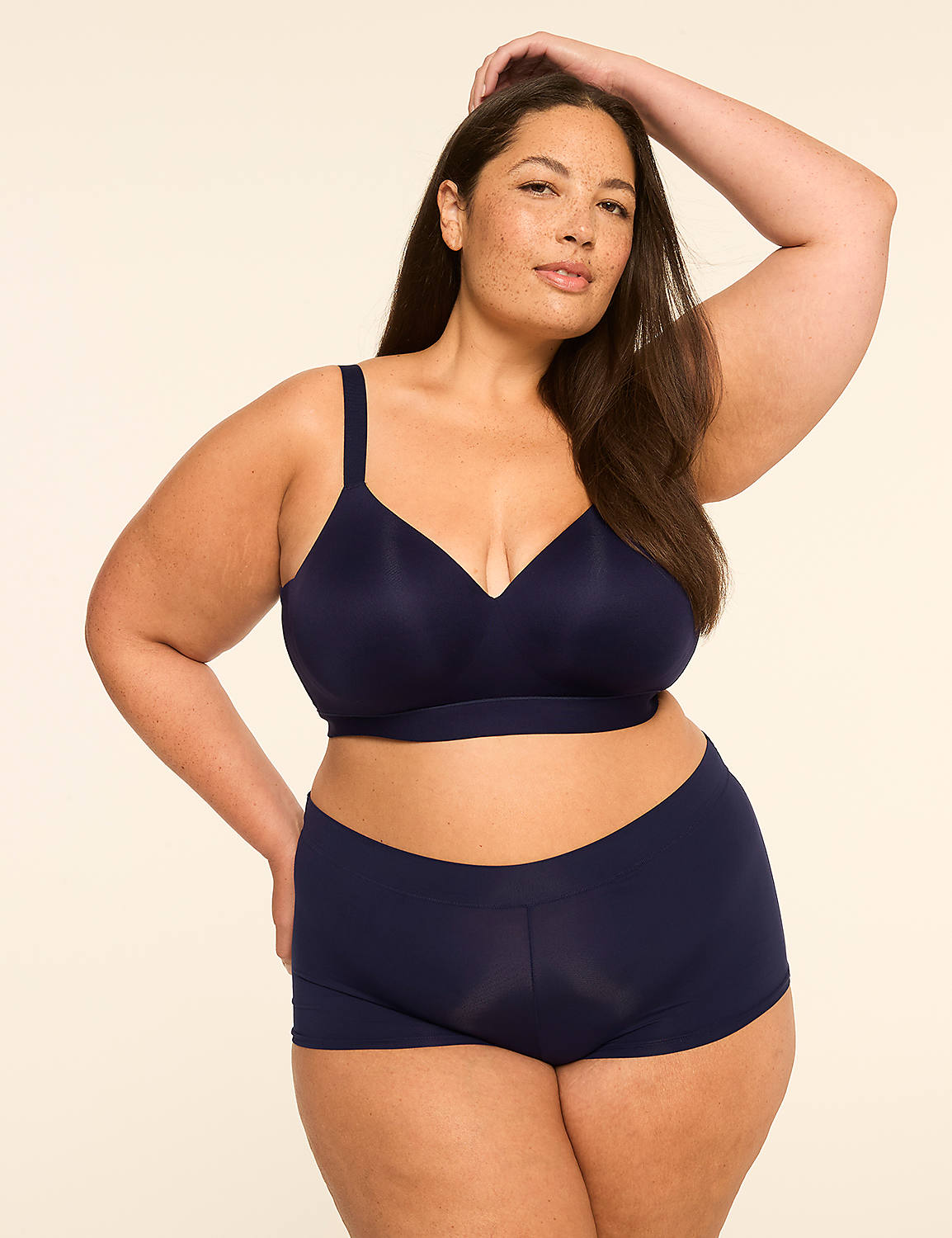 A woman in navy blue lingerie poses with her arm raised against a plain, light-colored background. Product Image 4