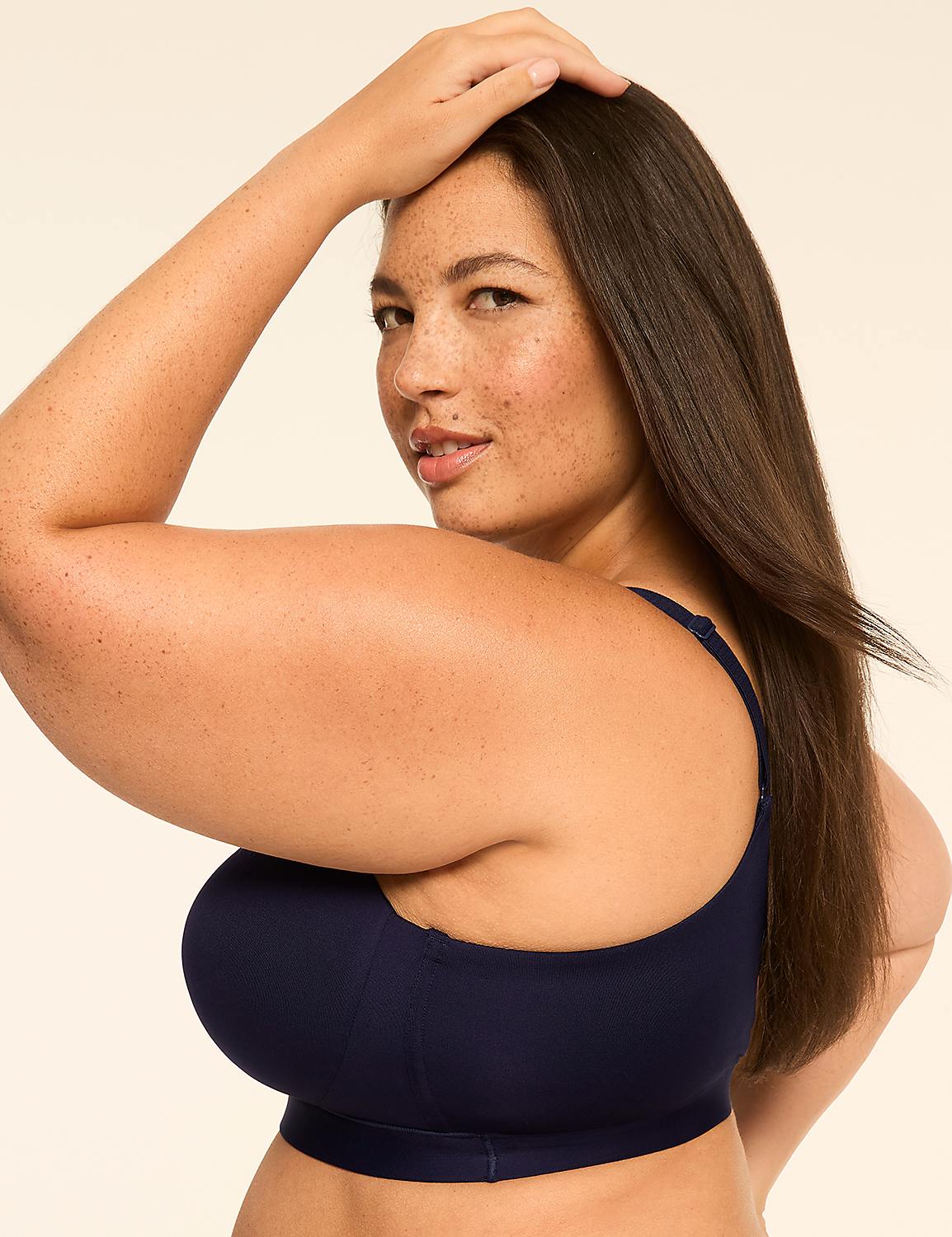 A woman with freckles in a navy blue bra poses with her hand on her head against a plain, light background. Product Image 3