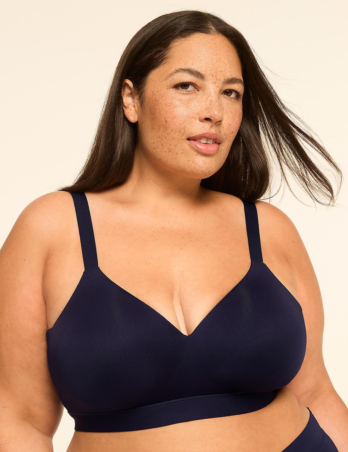 A woman with dark hair and freckles poses in a navy blue bra against a plain, light-colored background. Product Image 1