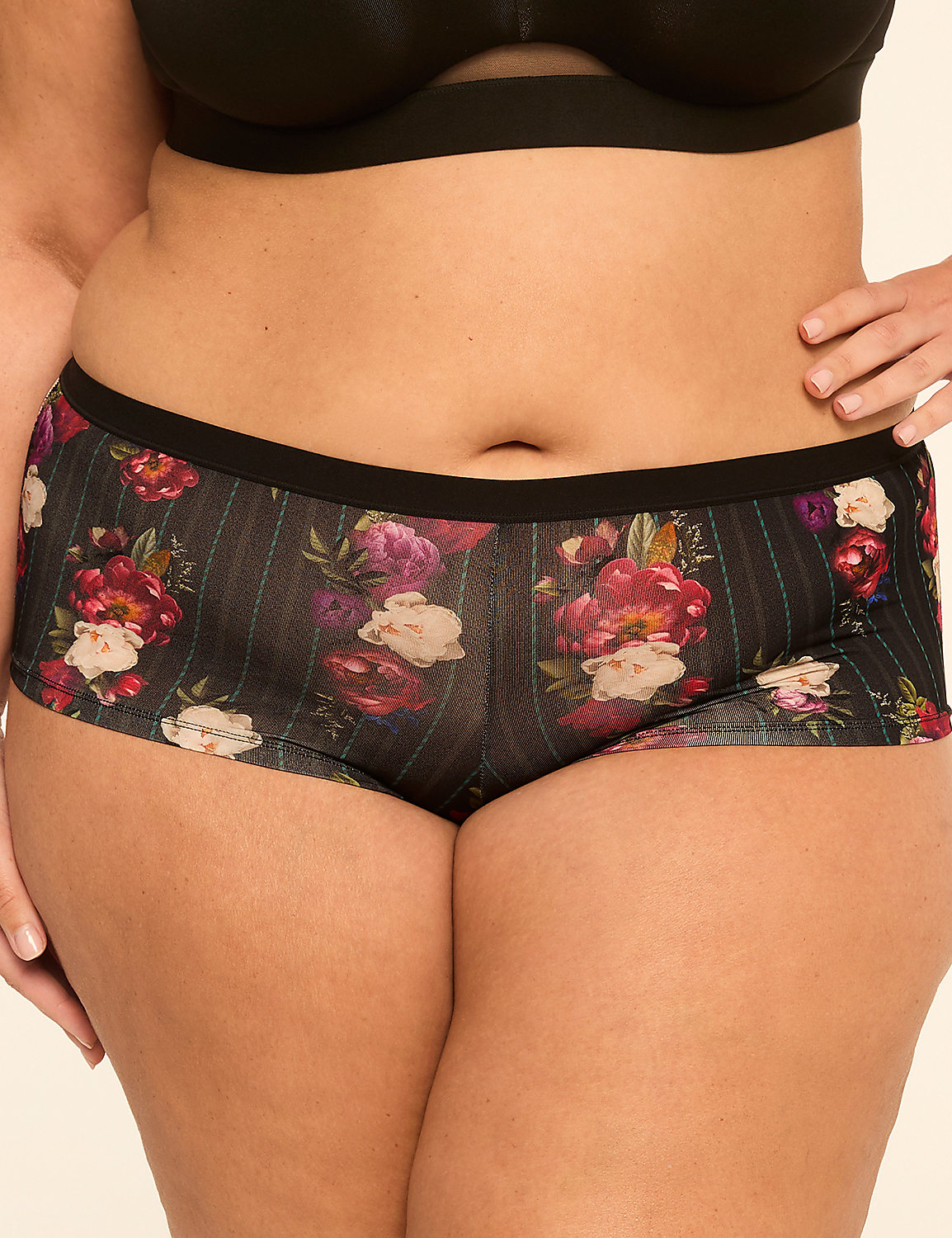 A woman's torso is shown from the waist down, wearing floral patterned boy shorts and a black bra, against a plain background. Product Image 1