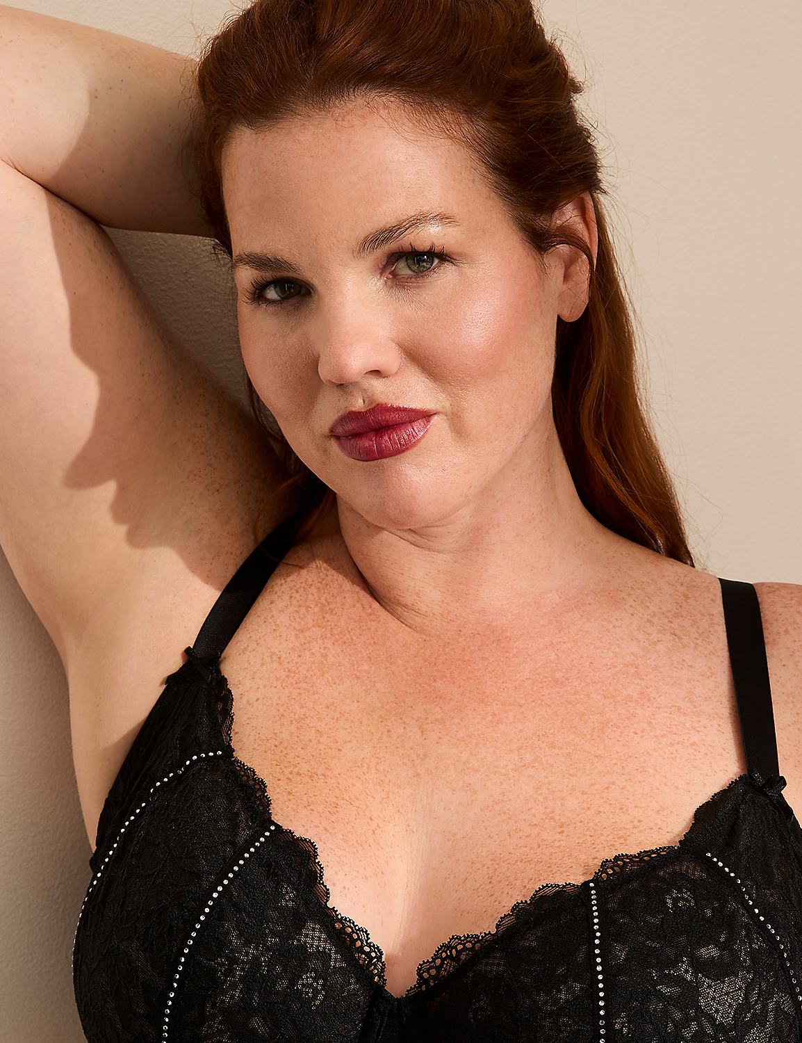 A woman with red hair and freckles poses in a black lace bra against a plain, light-colored background. Product Image 2