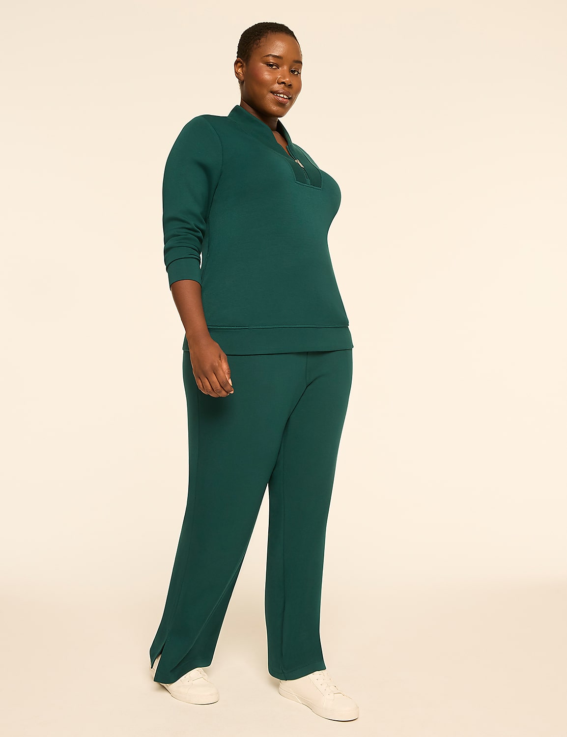 A woman in a green tracksuit stands against a plain, light-colored background. Product Image 3