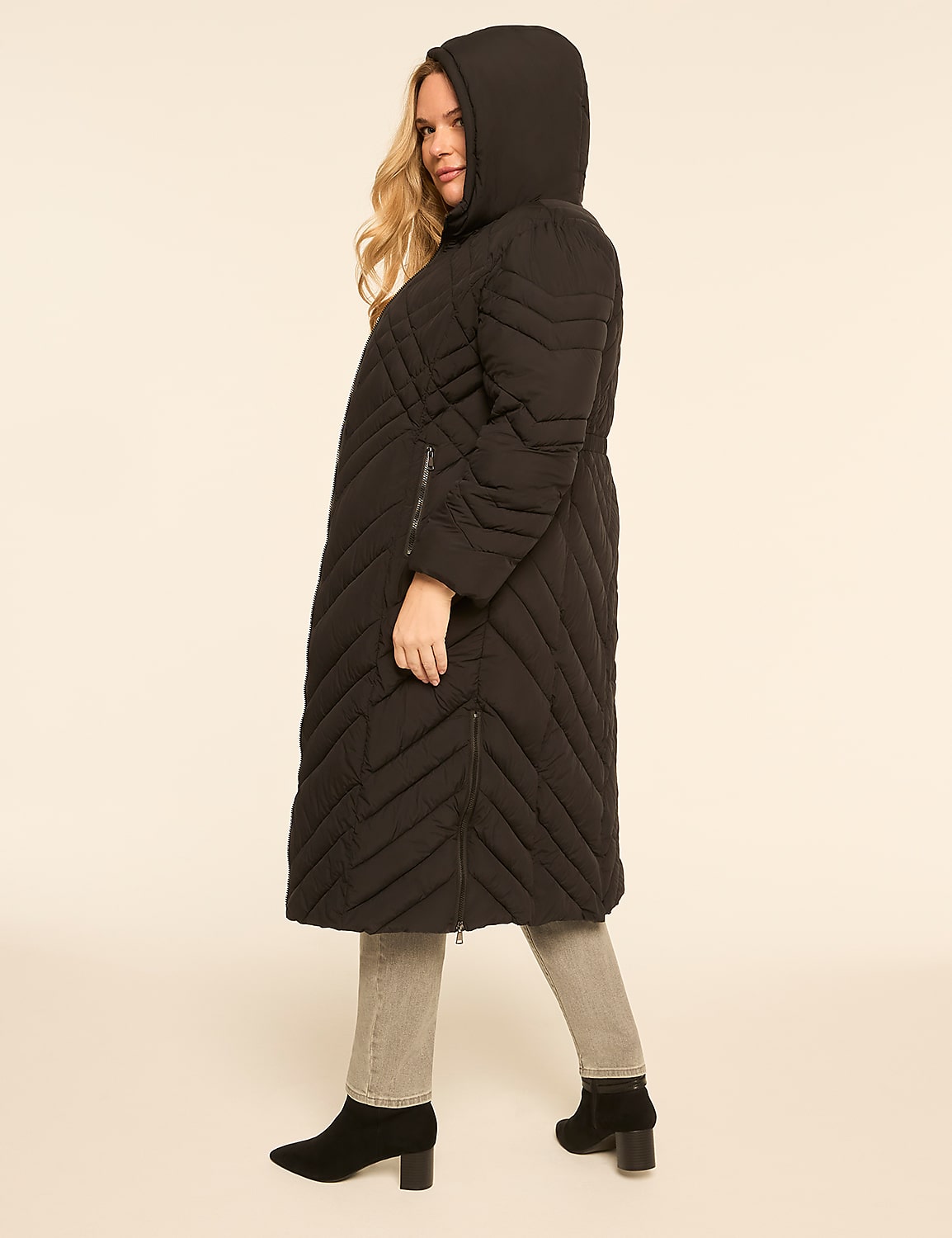 A woman in a black puffer coat and jeans stands against a plain, light-colored background. Product Image 2