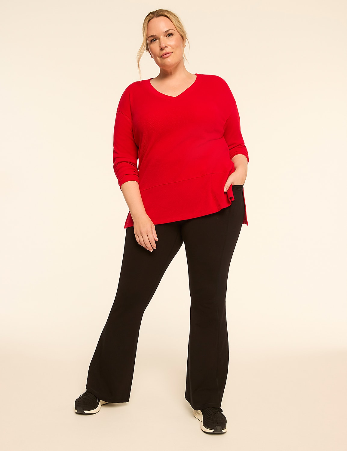 A woman in a red top and black pants stands against a plain, light-colored background. Product Image 3